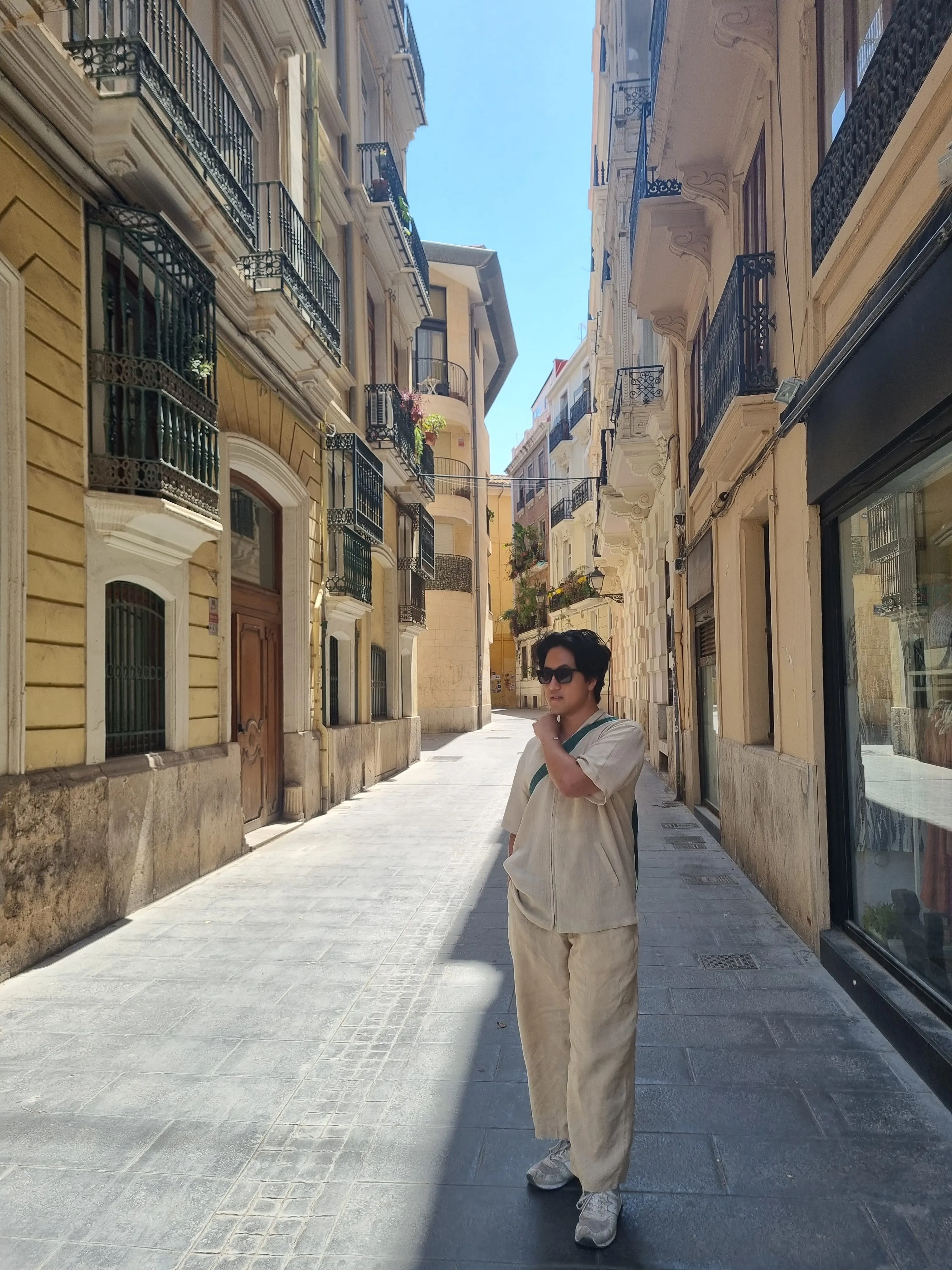 Dan walking through a sunlit street in Valencia